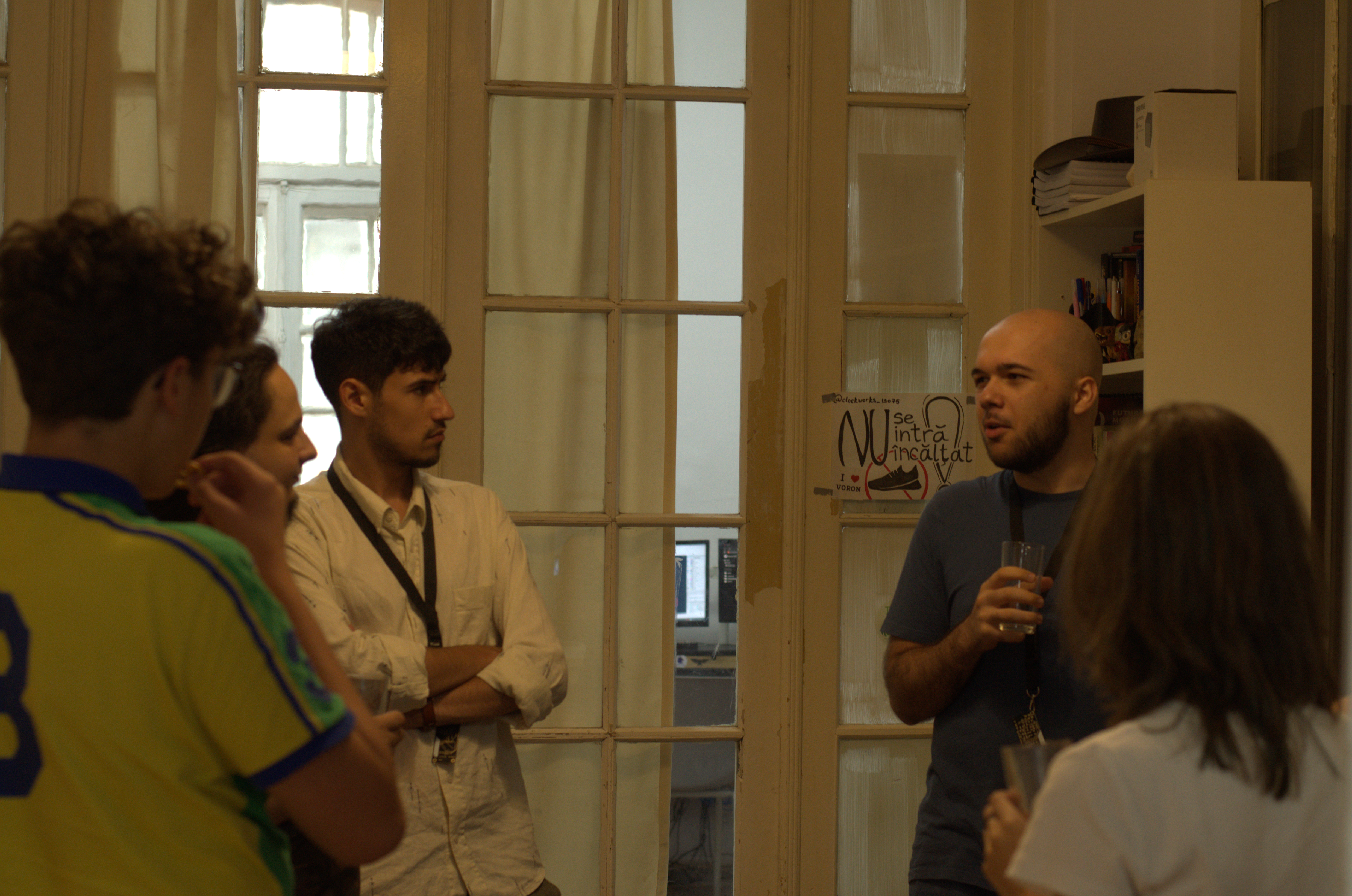 Group of people chatting in the Alacrity lab, one holding a drink