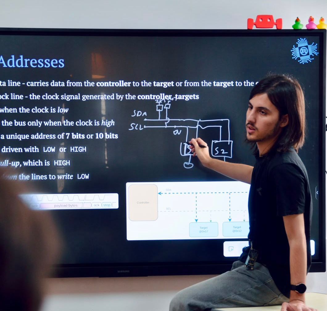 Instructor drawing an I2C bus diagram on an interactive display during a lesson