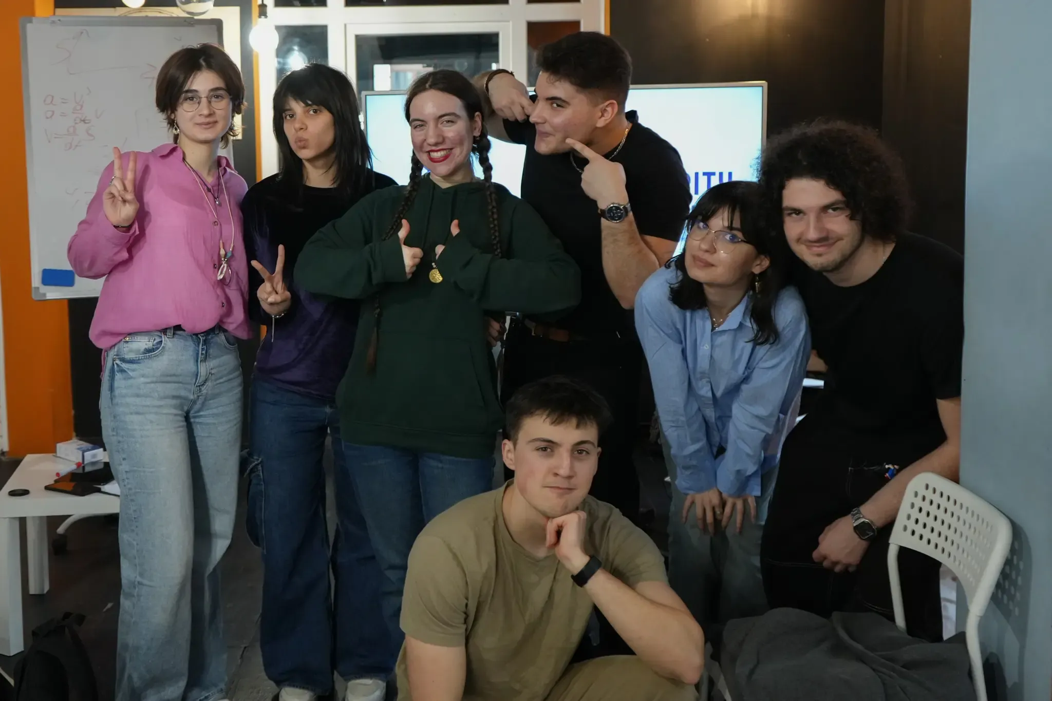 Alacrity Education team members posing together in the lab in front of a whiteboard